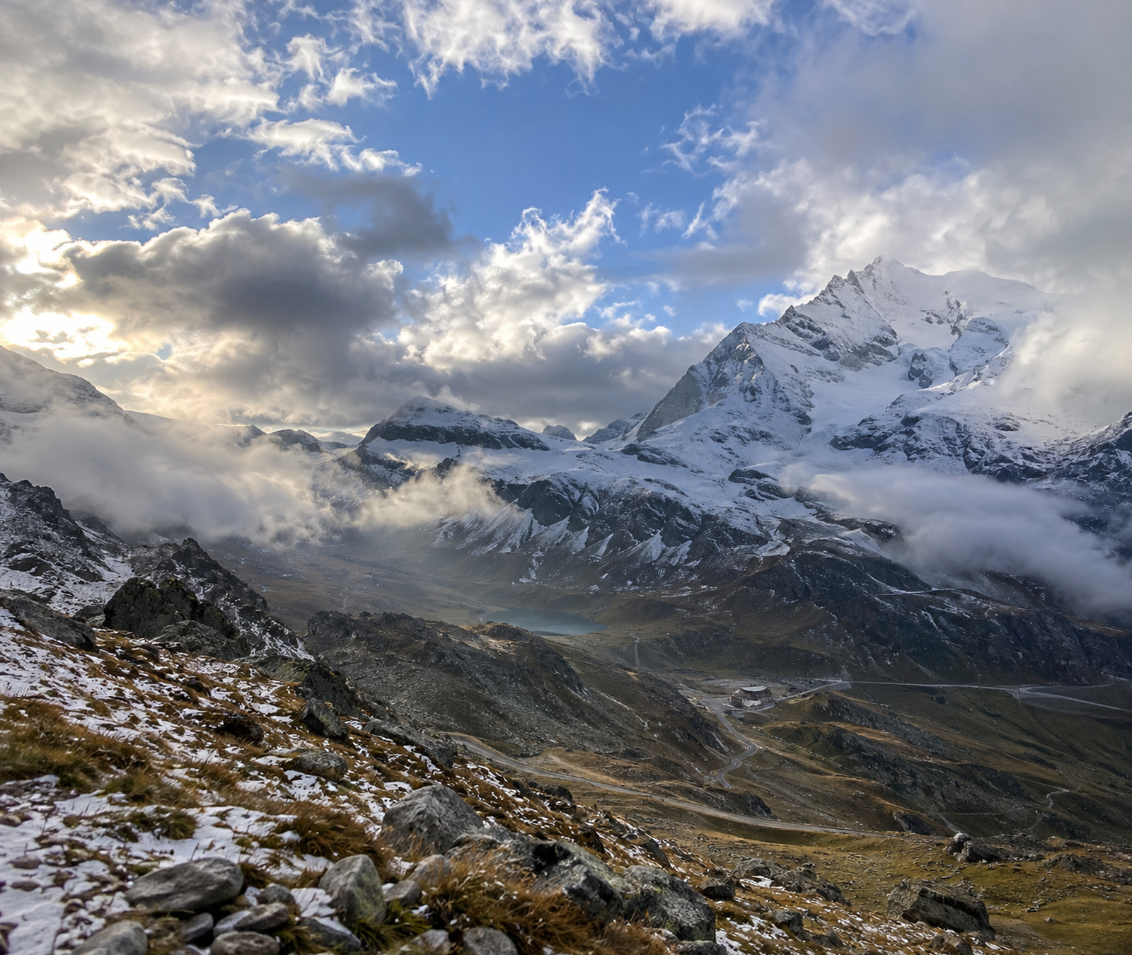Hochalpine Landschaft mit ersten Schneefeldern an den höchsten Gipfeln und noch weitgehend schneefreien tieferen Hängen