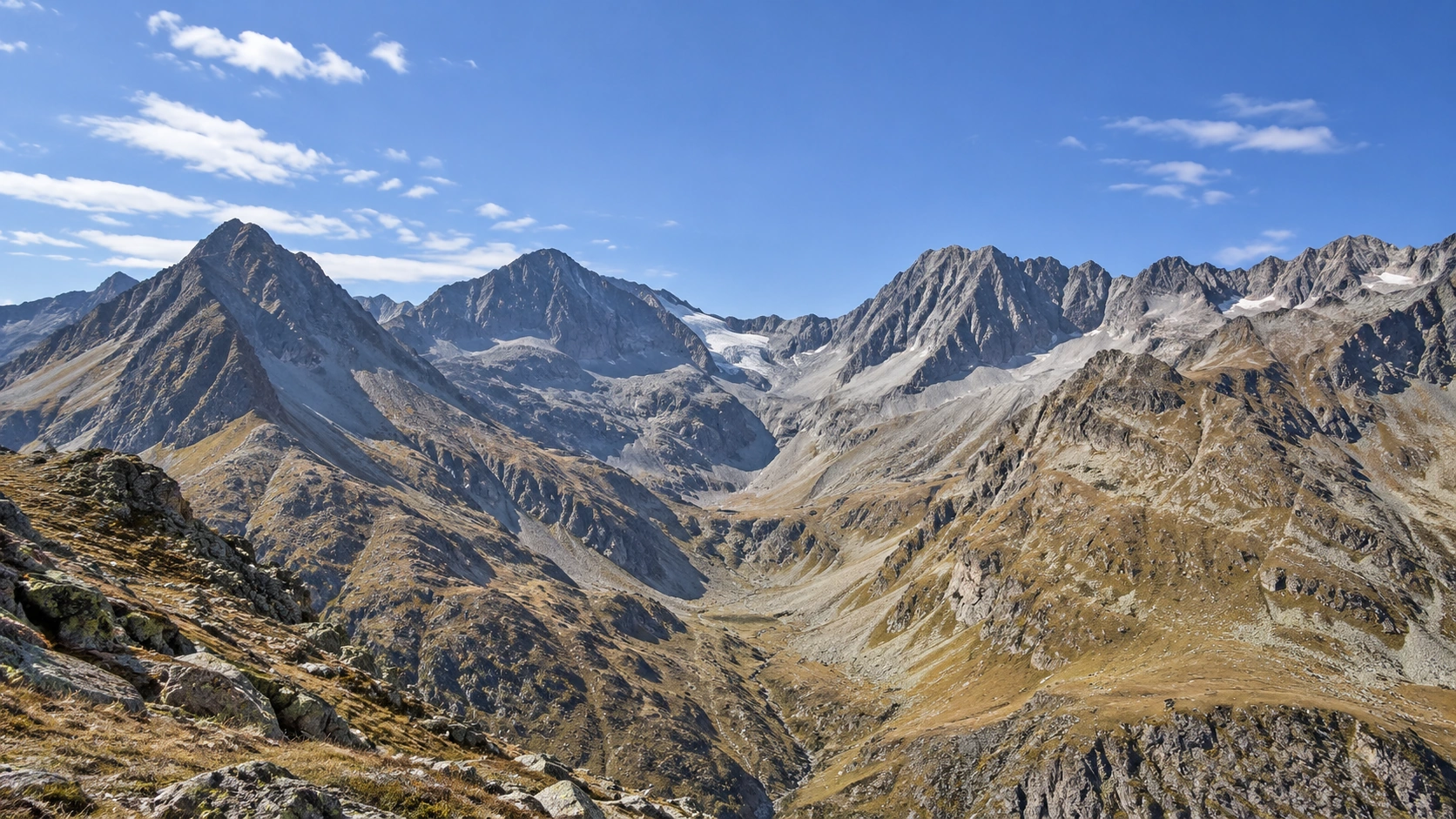 Weitgehend schneefreie hochalpine Felslandschaft mit kleinen alten Firn- und Gletscherresten in den höchsten Lagen.