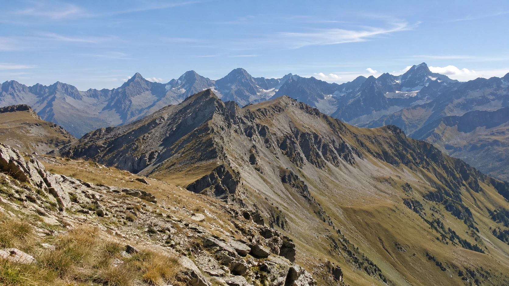 Weite felsige Hochgebirgslandschaft mit kargen Graten und nur alten Firn- oder Gletscherresten in höchster Lage.