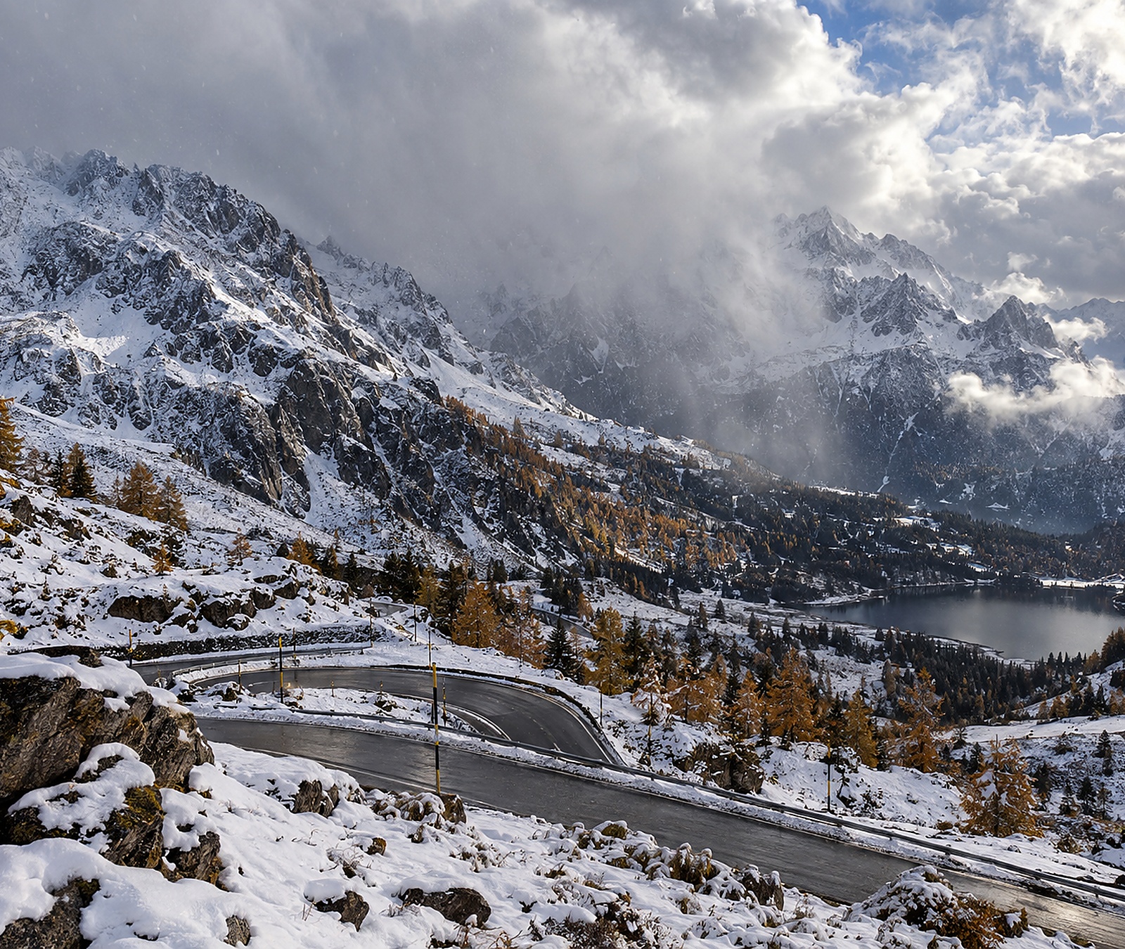 Frischer Schnee in einer hochalpinen Landschaft mit noch herbstlichen tieferen Lagen